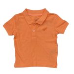 Shade of orange short sleeve top with collar and button with dinosaur design